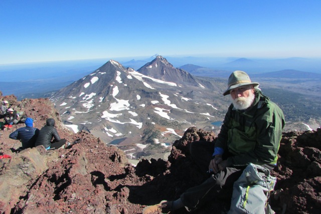 Photo of man with beard and hat at the top of a mountain in the Cascades, Oregon
