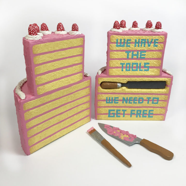 layered cake cut down middle with writing, "We have the tools, we need to get free"